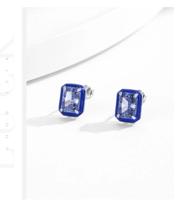 Macro shot of silver rectangle studs with blue enamel frame and emerald cut gemstone