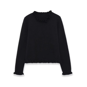 Detailed close-up of the ruffled mock neck and lettuce hem on this black knit sweater