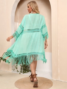 Detail of mint green crochet beach cover-up with long tassels and openwork design