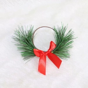 Christmas candle ring with green pine needles and a red ribbon bow for holiday decor