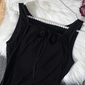 Close-up of black lace patchwork and back tie-knot detail on elegant bodysuit