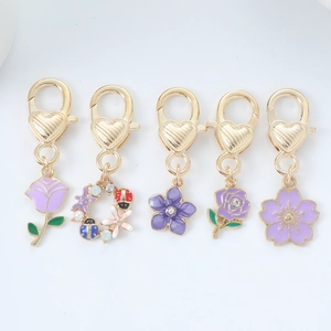 Detail view of five purple floral zinc alloy keychains with gold-tone lobster clasps