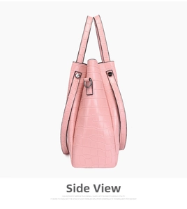 Side view of pink crocodile embossed leather bucket bag showing thickness and hardware