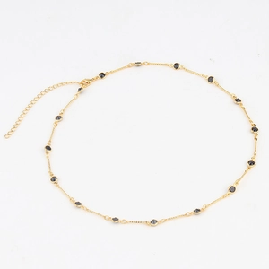 Detail of gold choker necklace with black circular stones and adjustable extender chain