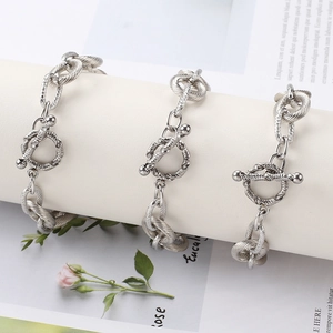 Detail of silver industrial textured chain bracelet with T-bar toggle closure on display