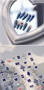 Macro detail of vintage blue denim nail stickers with leopard cross and heart patterns