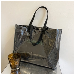 Detail of black transparent PVC tote bag with Skillfully text on a reflective surface