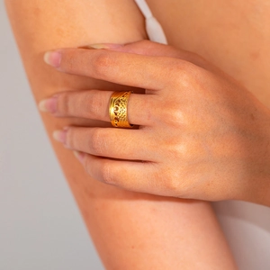 Detail of 18k gold plated stainless steel wide ring featuring ornate hollow patterns