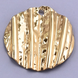 Macro view of a 304 stainless steel round pendant with textured pleated bark finish