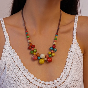 Gros plan d'un collier de perles colorées bohème sur mannequin avec haut de plage