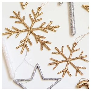 Close-up of glitter champagne snowflake and star ornaments for Christmas tree decor