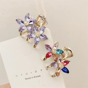 Floral crystal hair clips in purple and multicolor with gold metal base on display