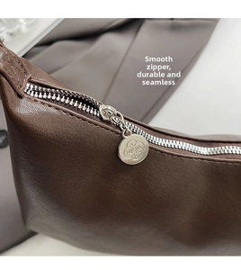 Detail of dark brown PU leather shoulder bag featuring smooth silver zipper and RICA logo