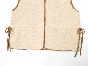 Detail of fleece vest with brown trim, metal zipper and adjustable side drawstring bows