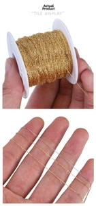 Detailed macro view of thin stainless steel O-chains in gold and silver on white spools