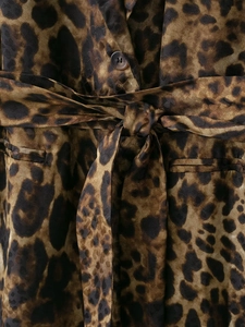 Dettaglio dell'abito leopardato con cintura in vita e trama di bottoni scuri