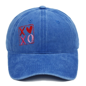 Dettaglio del ricamo rosso XOXO e del motivo a cuore sul berretto di cotone lavato blu navy