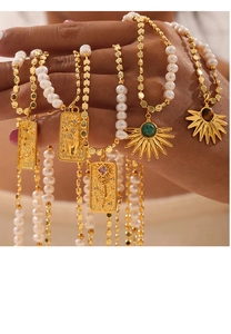 Detail of bohemian gold necklace featuring freshwater pearls and engraved sun pendants