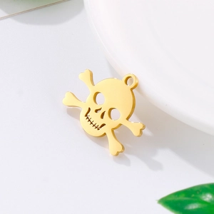 Golden skull and crossbones pendant necklace accessory on a white ceramic plate