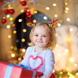 Girl wearing Christmas reindeer antler headband with gold bells and brown ears