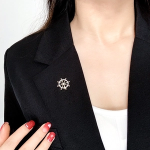 Close-up of golden helm brooch on a black suit lapel with opal-like floral details