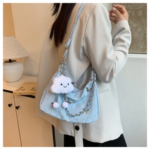 Detail of light blue crossbody bag with plush cloud and silver butterfly charm