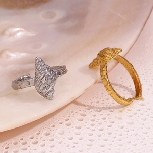 Detailed view of gold and silver conch shell rings with texture on pink shell surface