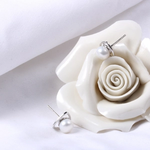 Elegant S925 silver triangle earrings with natural freshwater pearls on white fabric