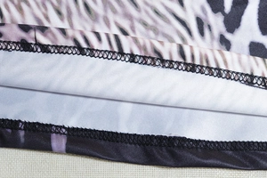 Close-up of double-needle hem stitching and snake print on high-elastic knit dress