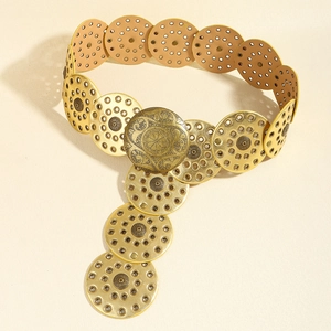 Macro view of vintage gold chain belt featuring embossed metal discs and floral patterns
