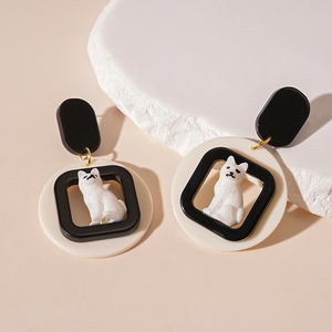 Detailed view of cute acrylic dog earrings featuring 3D puppy charm in a geometric frame