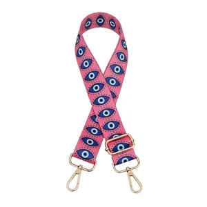Pink wide bag strap featuring blue Evil Eye patterns and gold adjustable buckles