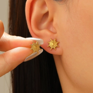 Vue détaillée d'une boucle d'oreille soleil en or mat montrant la taille réelle du produit