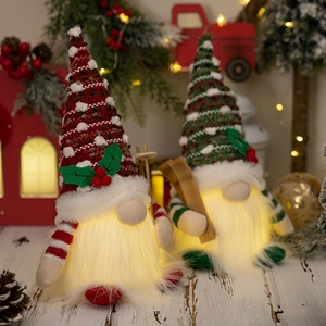 Detail of lit Christmas gnome ornaments with knit hats and warm glowing bodies