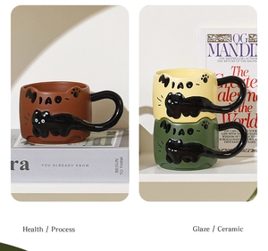 Detail of creative ceramic cat mugs in brown and green with tail handles and cat motifs