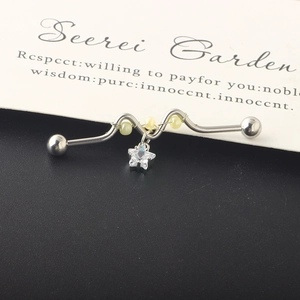 Macro view of silver industrial barbell earring with star zircon and yellow beads