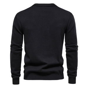 Back view of classic black knit cardigan showing ribbed cuffs and textured cotton fabric