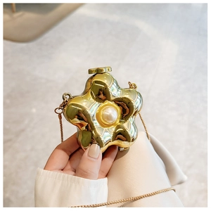 Macro view of gold flower acrylic mini bag with a large pearl center and chain