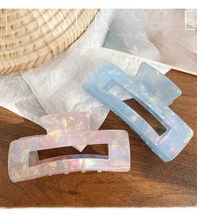 Close-up of pearlescent iridescent hair claws in pink and blue shell texture
