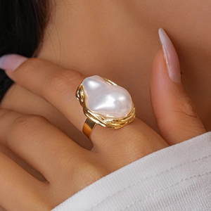 Macro shot of an elegant baroque pearl ring with golden twisted metal setting on finger