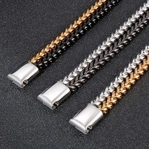 Detailed macro view of woven wheat chain bracelets in gold, black, and silver steel