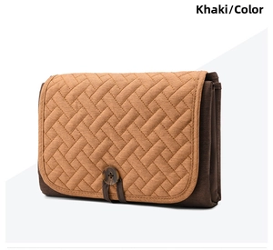 Folded khaki portable diaper changing pad with woven texture and a wooden button closure