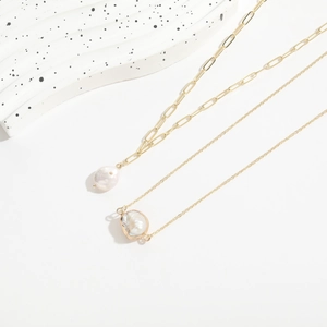 Close-up of gold paperclip chain and freshwater baroque pearl pendant on 14K gold necklace