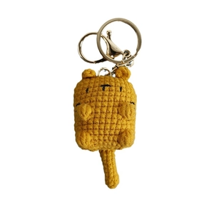 Handmade yellow crochet cat keychain with gold metal ring on a plain white background
