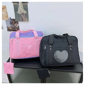 Detail of JK uniform ita bags in pink and black with heart windows and coin purses