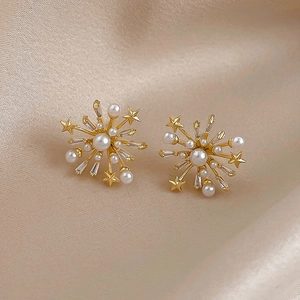 Detail of starburst earrings featuring white pearls and rectangle zircons on silk background