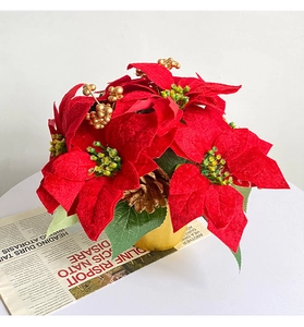 Detail of red poinsettia Christmas centerpiece with gold berries and pine cones