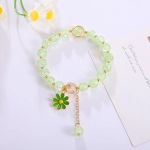 Handmade beaded flower bracelet with green crystal beads and daisy charm on white background