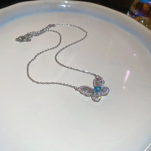 Detailed macro of silver butterfly pendant with zircon crystals and light blue cat-eye stone