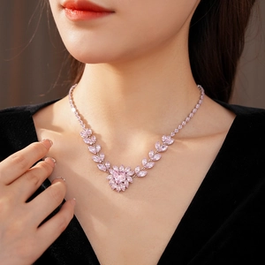 Gros plan d'un collier pendentif cœur en zircon rose avec monture florale en argent
